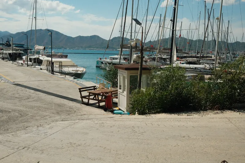Sailboats moored at a marina beneath distant mountains
